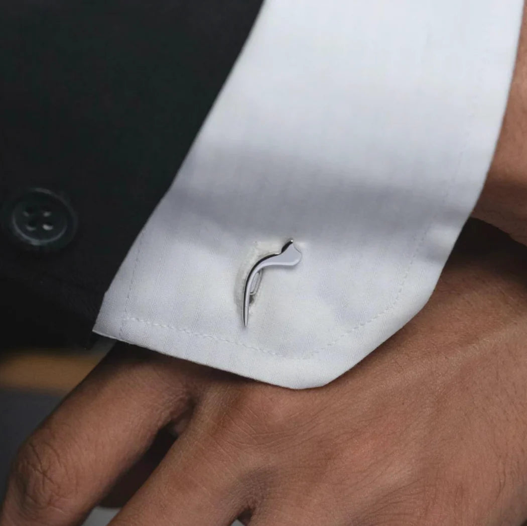 Close-up of a white shirt cuff with a silver cufflink.