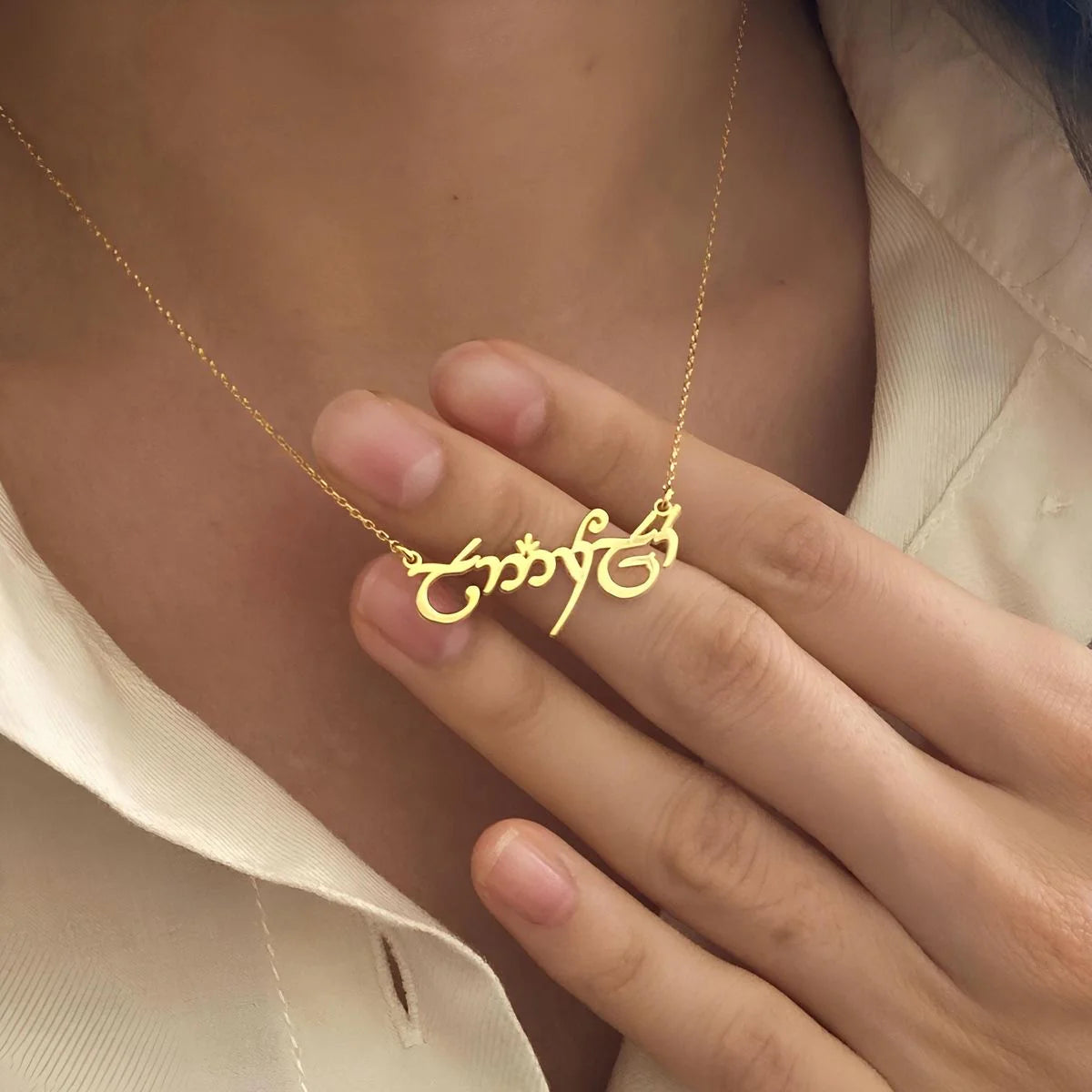 Gold necklace with an intricate design worn by a person
