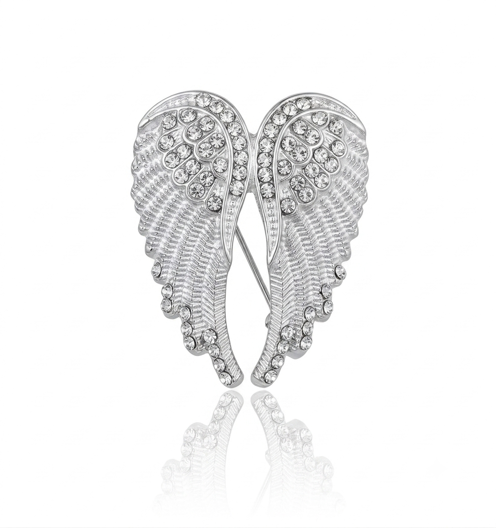 Silver angel wings brooch embellished with clear rhinestones, displayed on a clean white background with a soft reflection below.