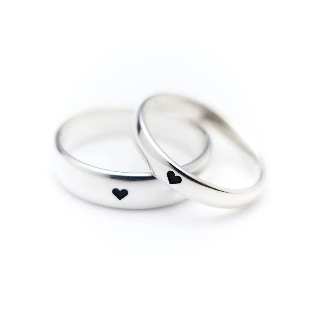 Two silver rings with heart-shaped cutouts on a white background